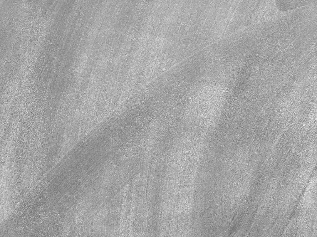 Un tableau noir essuyé avec une brosse sèche, laissant des traces de craie partout.