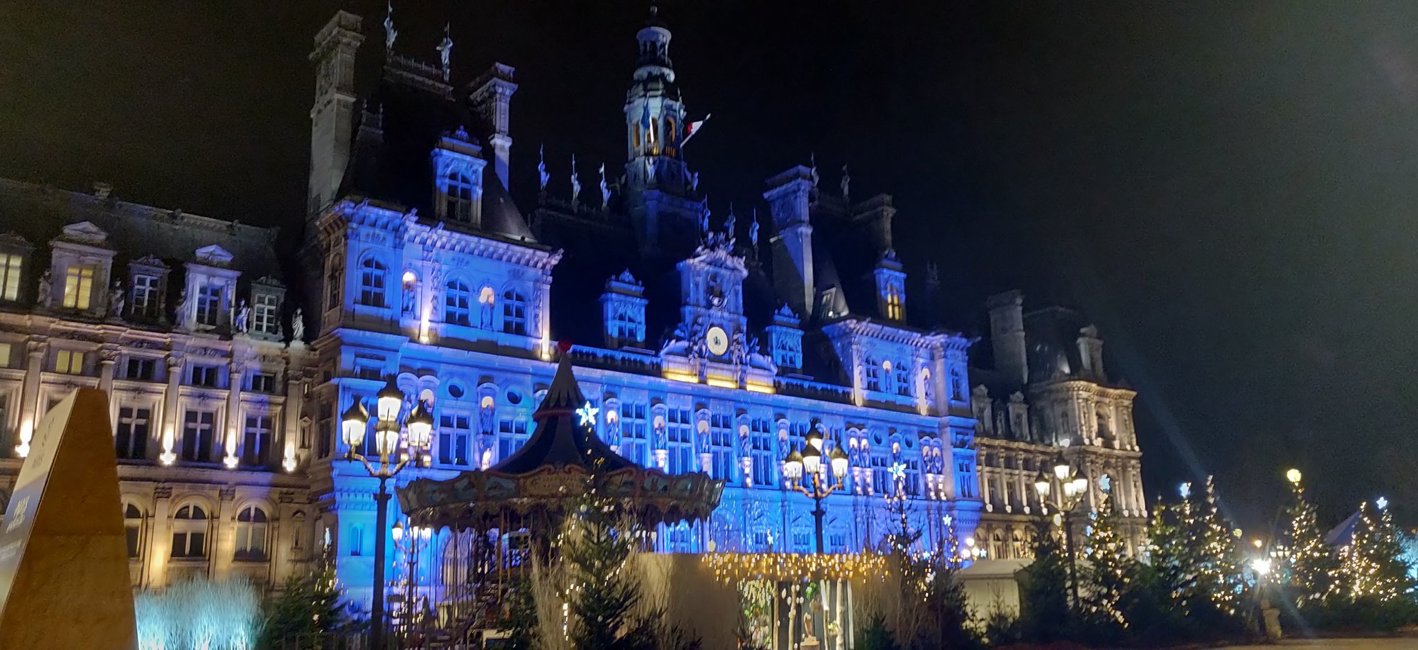 L'hôtel de ville de Paris, avec un éclairage bleu illuminant la façade.