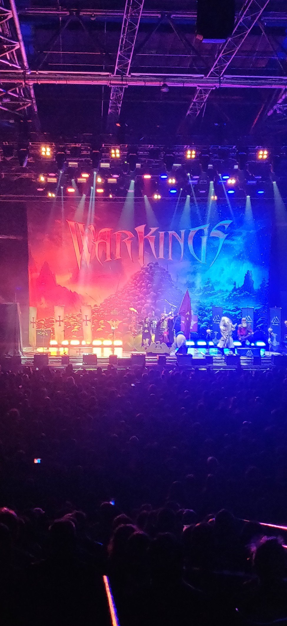 Scène du Zenith avec un éclairage rouge et bleu, le logo Warkings en fond et une foule devant.
