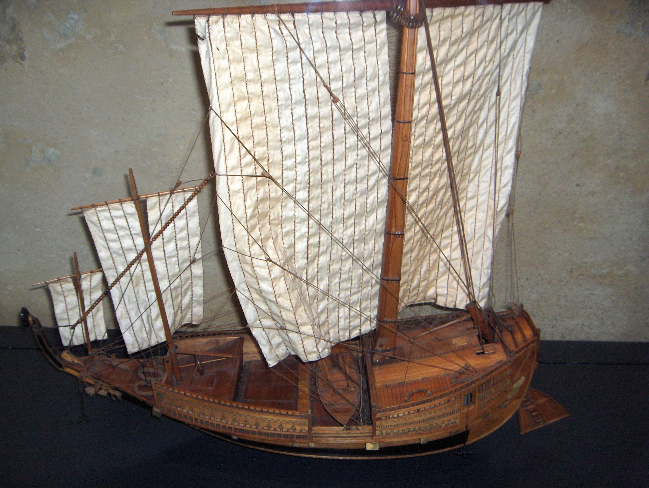Maquette de bateau avec un canot occupant toute la largeur, et trois voiles de taille croissante en partant de la proue