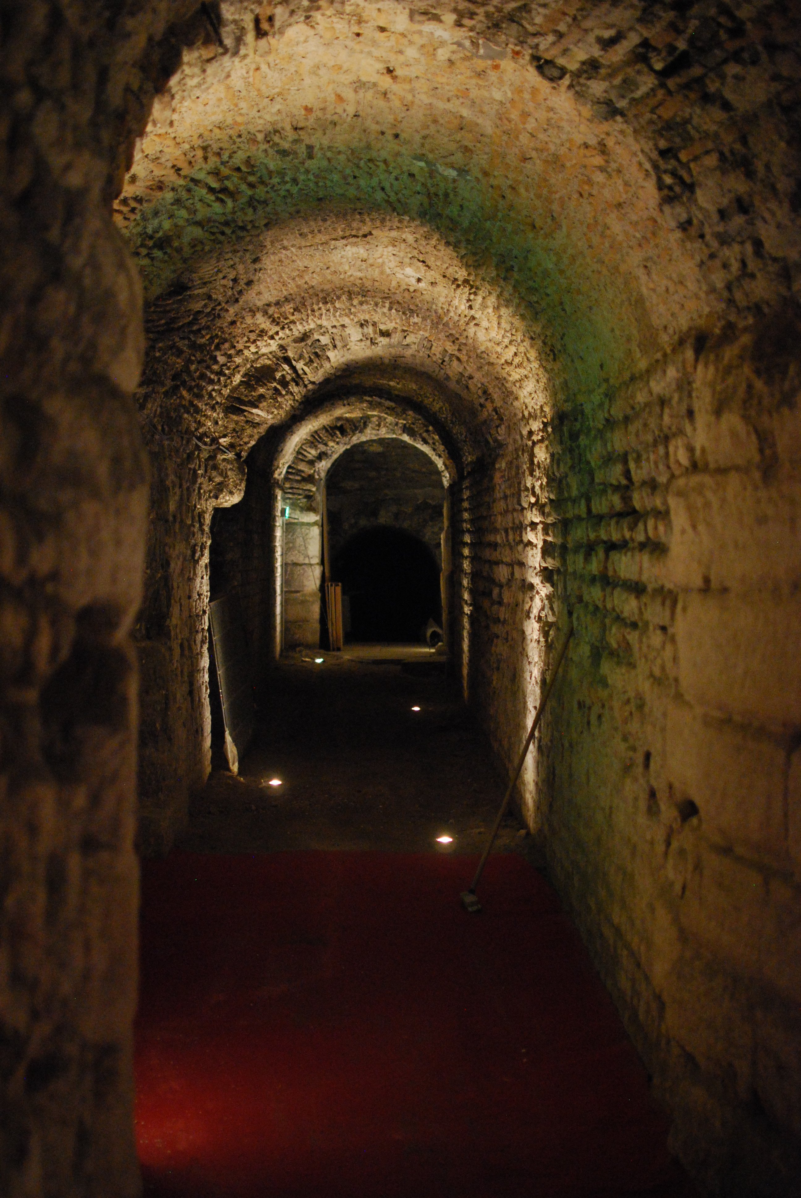 Un couloir en pierre avec le plafond en arche romane.