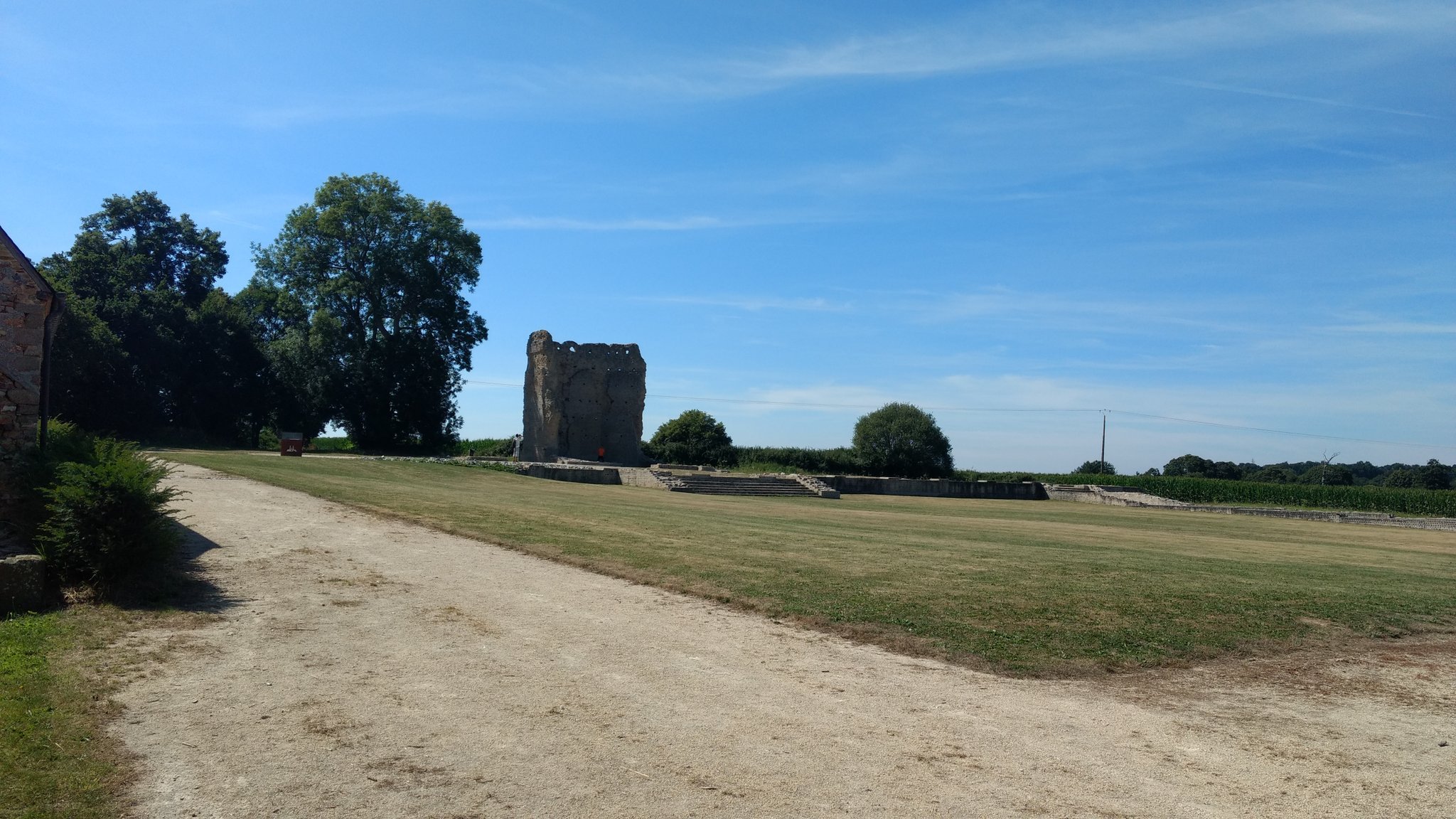 Un grand espace dégagé avec un bâtiment en ruine au fond